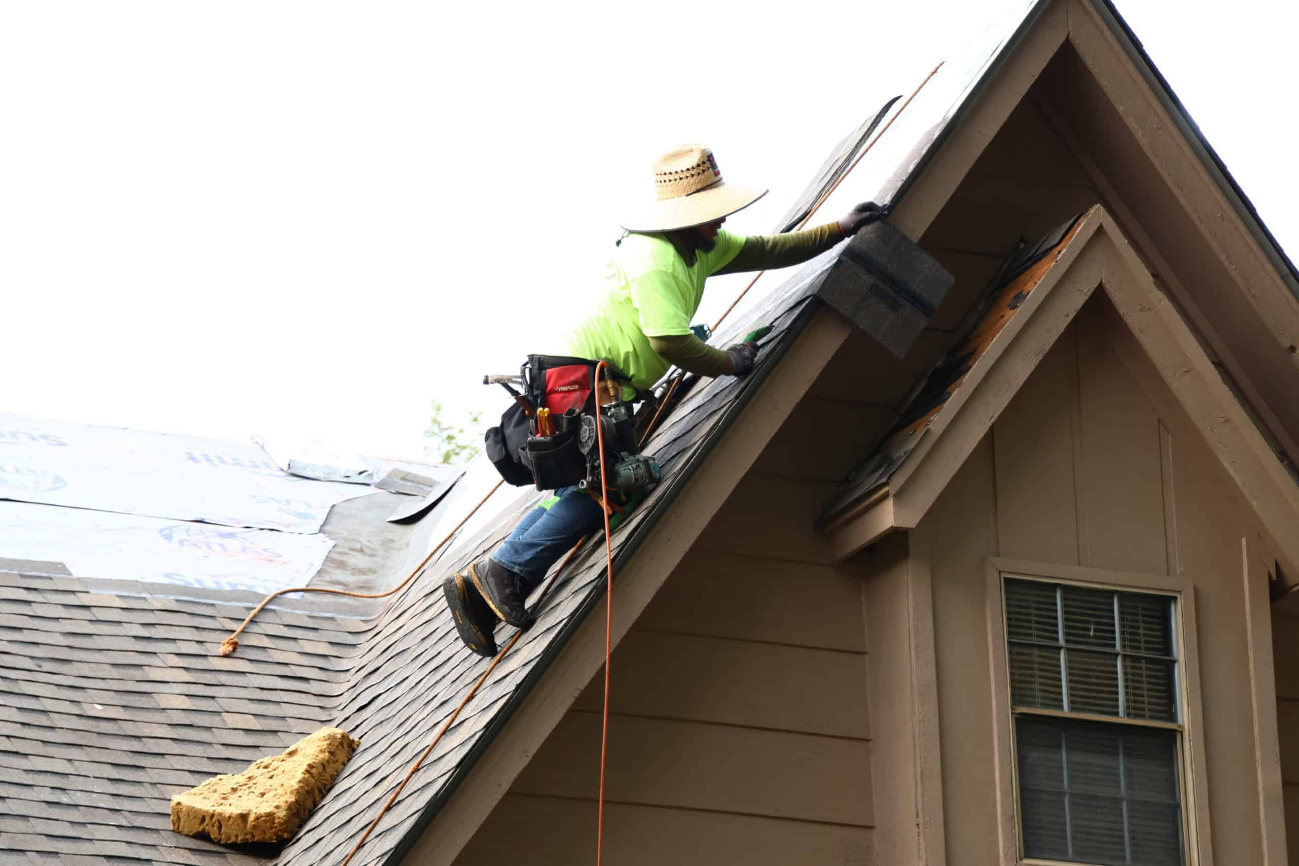 Roofing professional installing shingles on a residential roof for quality roofing services.